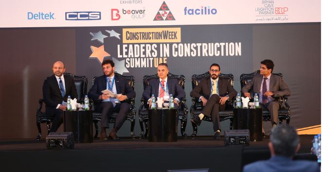 5 men seated on a stage at Leaders in Construction